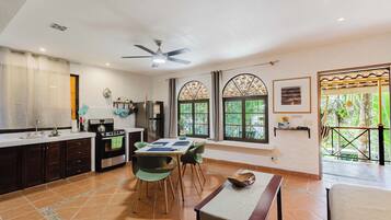 Una cocina moderna con comedor, ventanas amplias y un ventilador de techo.