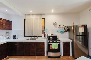 A compact kitchen with a stove, sink, and modern appliances.