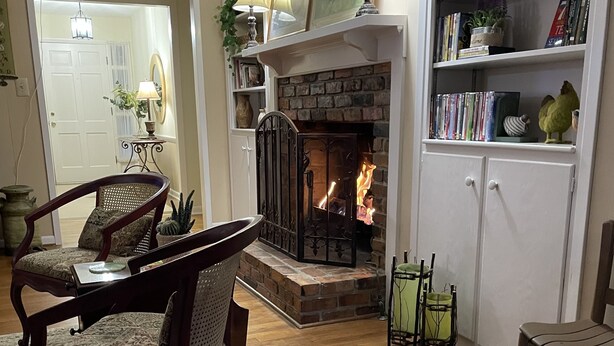 Ein gemütliches Wohnzimmer mit Kamin, Holzmöbeln und einer Bücherwand.