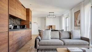 A modern living room with a grey sofa, wooden cabinets, and a coffee table. - Remarkable Wiedikon 2BR w/ Storage & W/D, nr Market, by Blueground (Zurich)