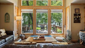 A cozy living room with a large window, a fireplace, and a comfortable seating area.