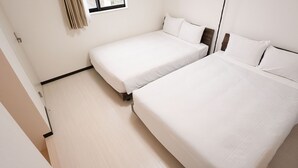 A hotel room with two single beds, a window with curtains, and a light-colored floor. - KARCHIBE ISHIGAKI (Ishigaki)
