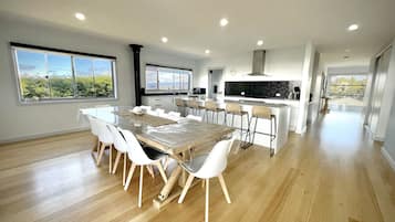 A modern kitchen with a central island, white cabinetry, and a large window offering a view of greenery.