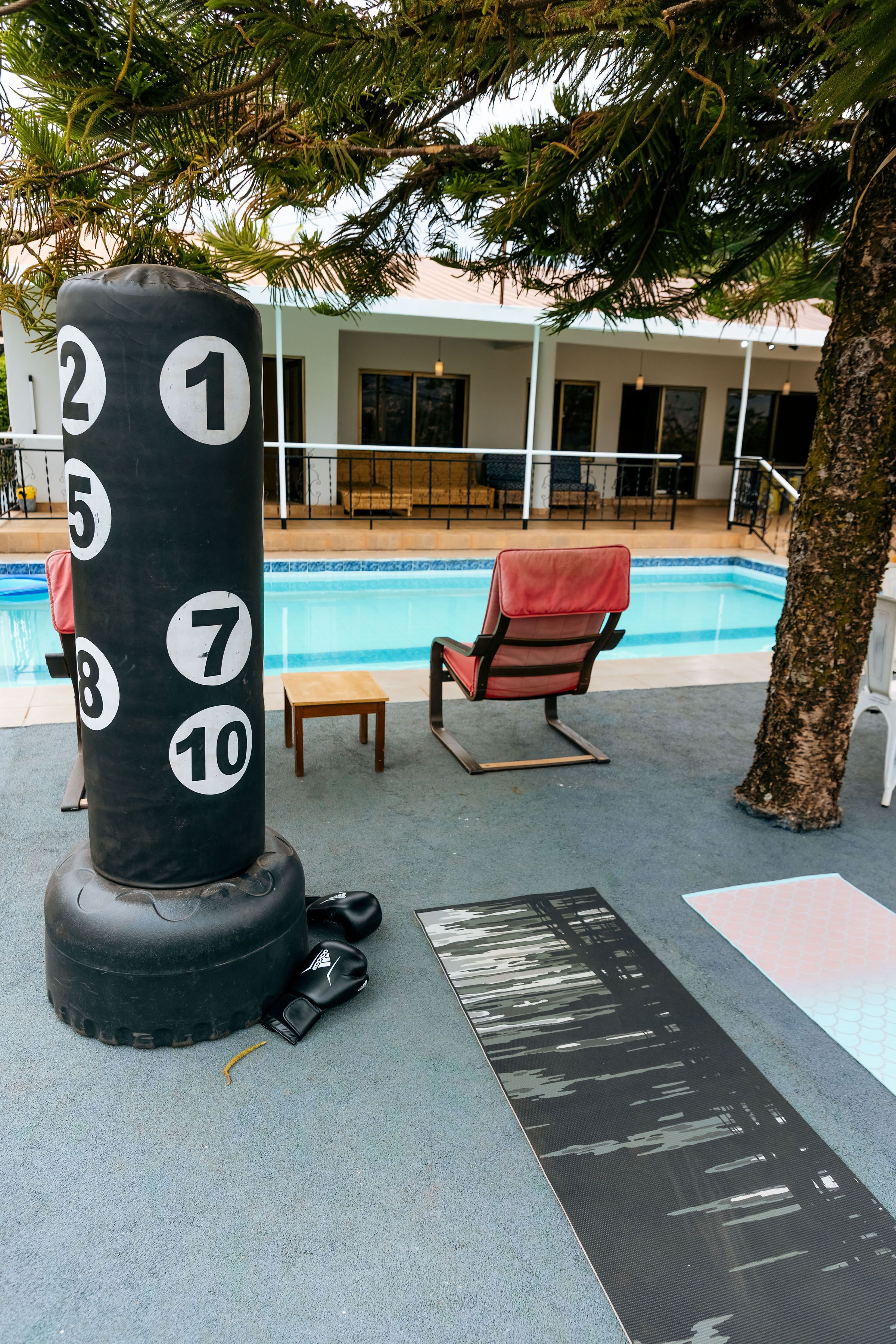 Un sac de frappe avec les chiffres de 1 à 10, une piscine, une chaise et une petite table.