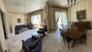 A dining area with a round table and chairs, a sofa, and a chandelier. - 2 Bed Flat - Sleeps 6 - Pets - Parking - Wifi (Metn)