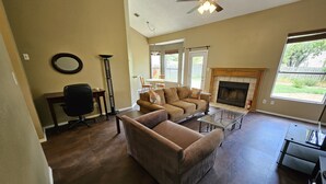 A living room with a fireplace, a sofa, a coffee table, and a ladder.