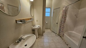 A bathroom with a sink, mirror, and shower.