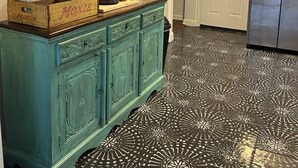Una cocina con un mueble azul turquesa, una cafetera y un refrigerador.