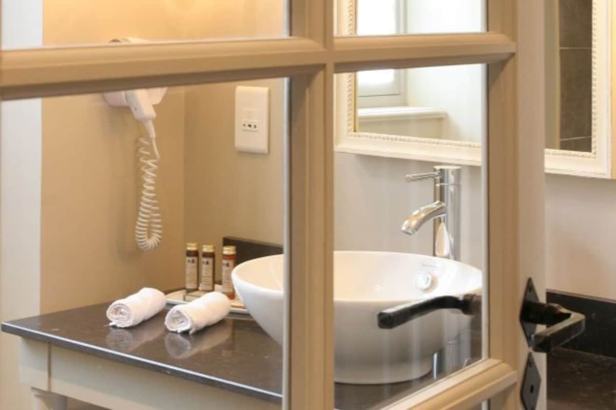 A bathroom with a white sink, a mirror, and a towel rack.
