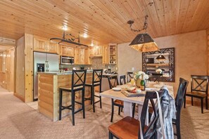 A log cabin interior with a kitchen, dining area, and a large mirror.