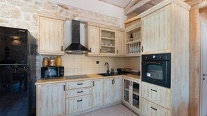 Una cocina con armarios de madera, una estufa negra, un microondas y un lavabo.
