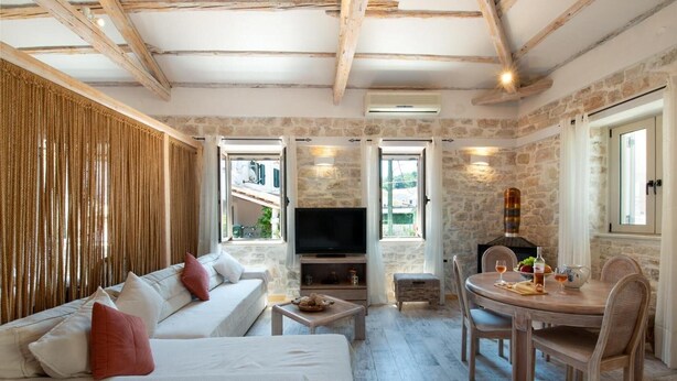 Una sala de estar acogedora con sofá, televisor y comedor con mesa y sillas.