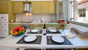 A modern kitchen with a dining area set for a meal. - Dora II Studio - Simple Sweet Getaway (Paxos)