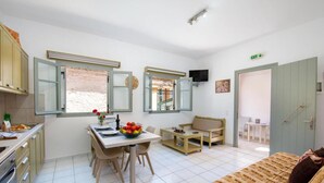 A compact living space with a dining area, kitchenette, and a sofa. - Dora II Studio - Simple Sweet Getaway (Paxos)