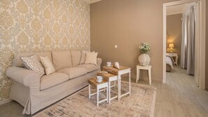 Ein Wohnzimmer mit einem beigefarbenen Sofa, einem Holztisch und einer Wand mit Muster