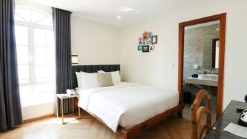 A hotel room with a bed, bedside table, and a mirror.