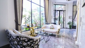 A spacious living room with a sofa, a glass coffee table, and a decorative globe. - Mettavary Hotel (Phnom Penh)