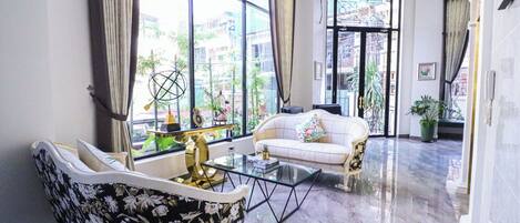 A spacious living room with a sofa, a glass coffee table, and a decorative globe.