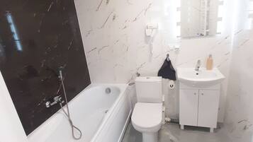 Une salle de bain moderne avec une baignoire, des toilettes et un lavabo.