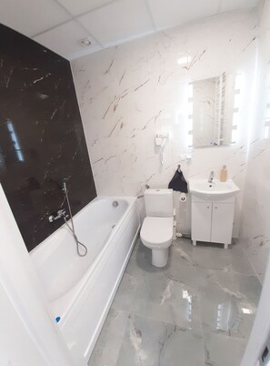 Un baño moderno con bañera, inodoro y lavamanos.