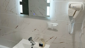 A bathroom with a white sink, a mirror, and a hairdryer on the wall. - Souvenirappart Sienkiewicza 3B (Bydgoszcz)
