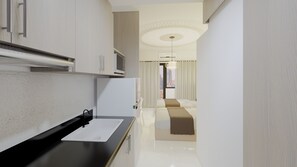 A modern hotel room with a kitchenette, a bed, and a view of the cityscape.