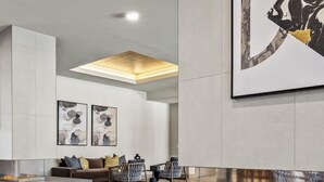 Uma sala de estar moderna com lareira, área de estar e obras de arte nas paredes.