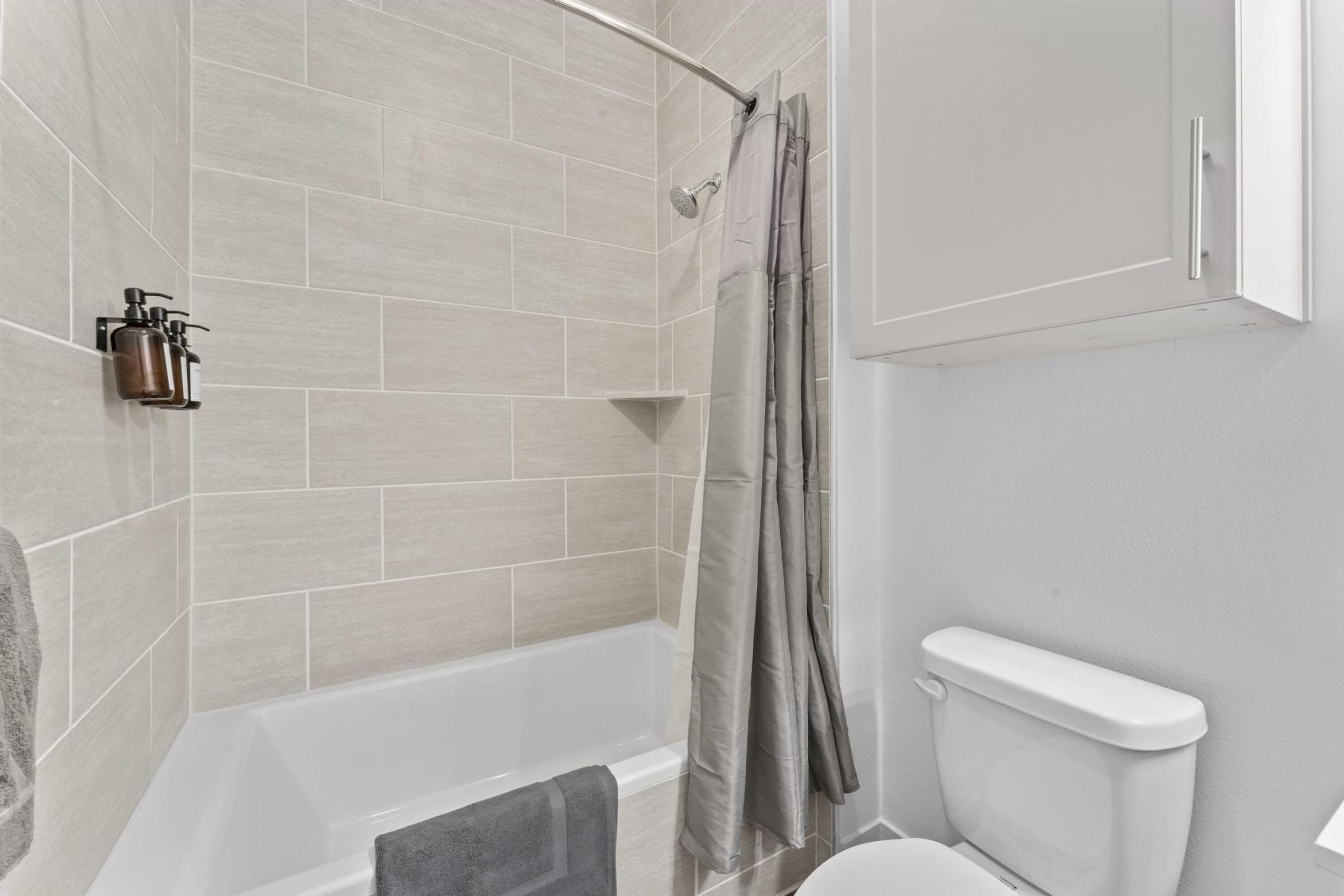 Ein modernes Badezimmer mit Dusche, Toilette und Handtuchhalter.