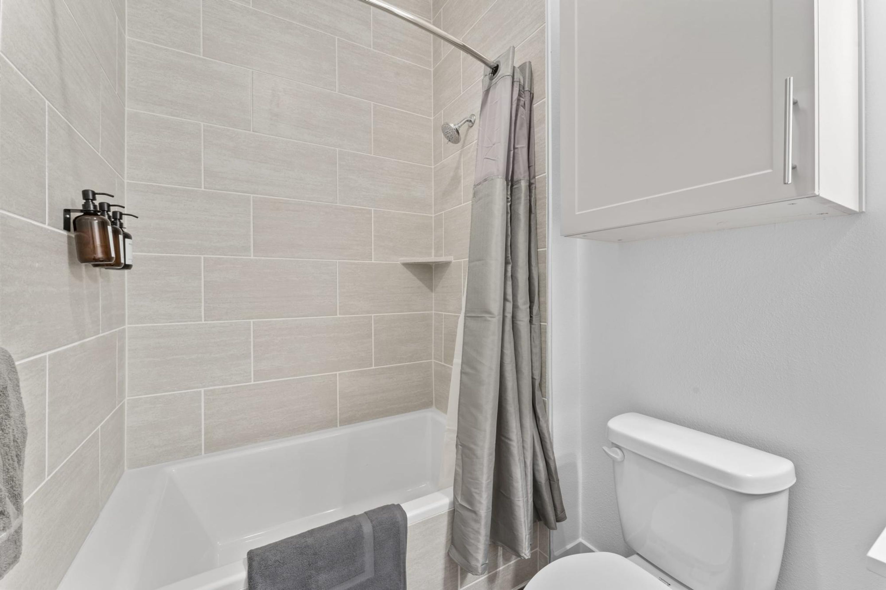 Et moderne badeværelse med badekar, bruser og toilet.
