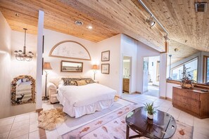 A bedroom with a large bed, a wooden ceiling, and a view to the outside. - Deer Valley Fawngrove 1486 (Park City)