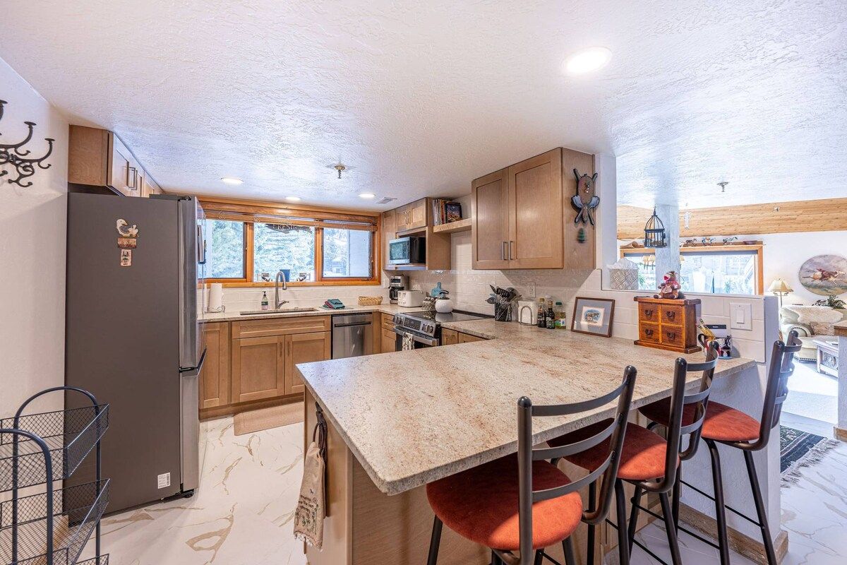 A modern kitchen with a granite countertop, wooden cabinets, and a built-in oven.