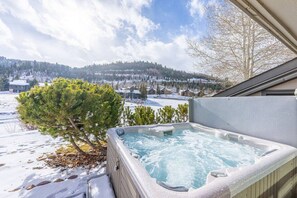 A hot tub with a snowy landscape and trees in the background. - Deer Valley Fawngrove 1486 (Park City)