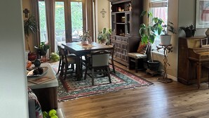 Un espacio habitable amplio con una mesa de comedor de madera, una chimenea y un ventanal grande.