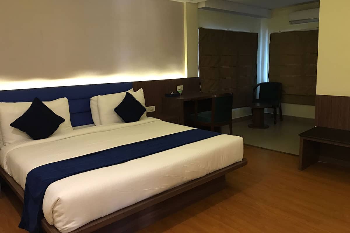Una habitación de hotel con una cama grande, un escritorio y una silla.