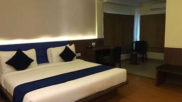 Una habitación de hotel con una cama grande, un escritorio y una silla.