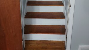 Una escalera con escalones de madera y paredes blancas.