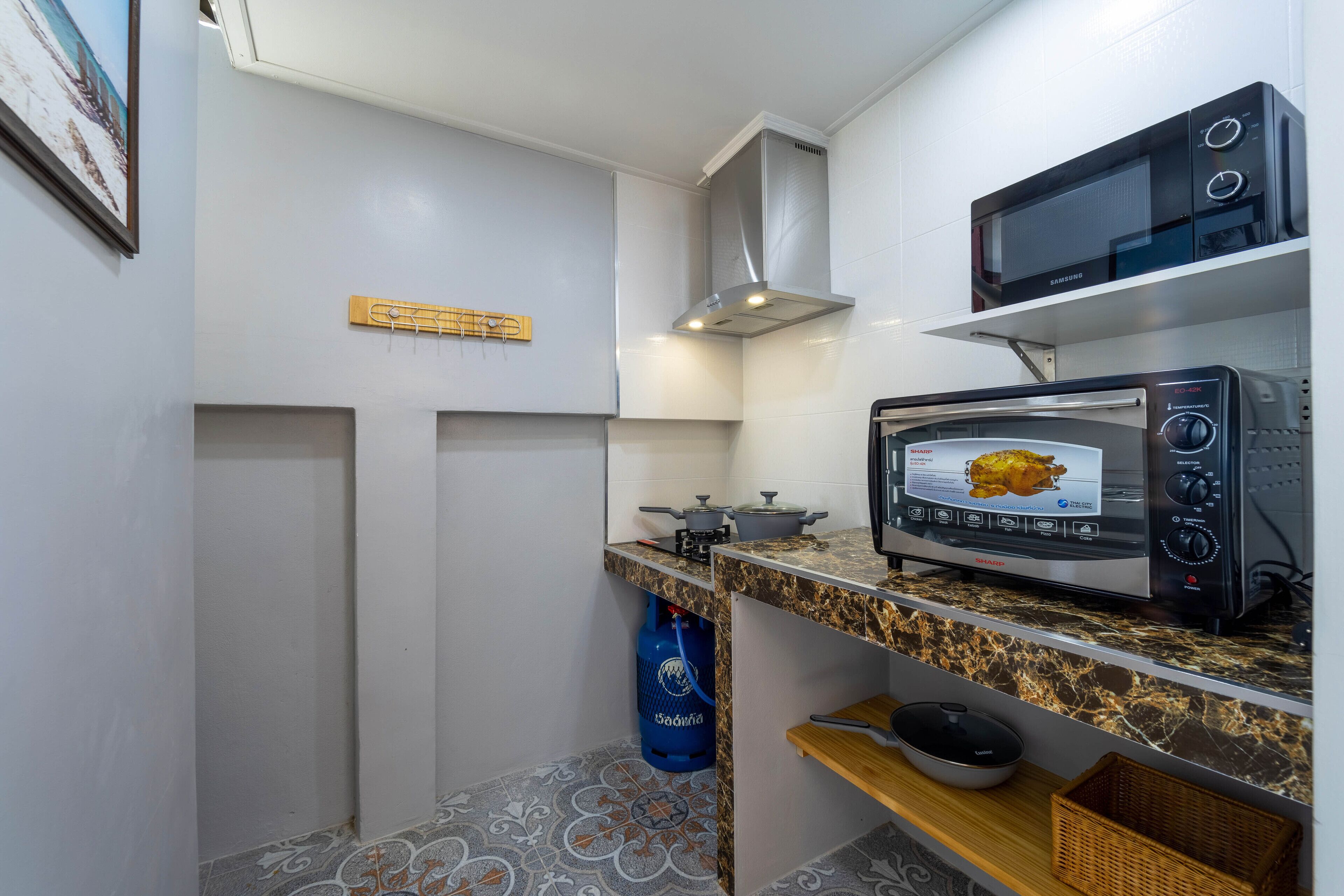 A compact kitchen with a microwave, toaster, and gas stove.