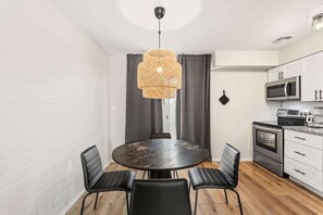 A compact kitchen with white cabinets, a microwave, and an oven.