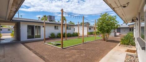A residential property with a covered patio, a small lawn, and a gravel area.