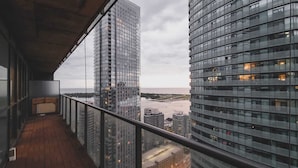 A balcony with a view of modern high-rise buildings and a body of water.