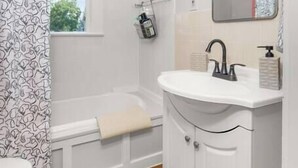 A bathroom with a toilet, a bathtub, a sink, and a shower curtain. - 2BR + 1BA, Small Town Feel, Pets Allowed (Spokane)