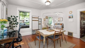 A dining area with a wooden table, chairs, and a vase of flowers. - 2BR + 1BA, Small Town Feel, Pets Allowed (Spokane)