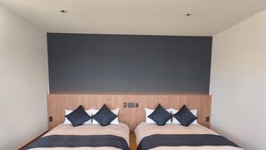 A double bed with a wooden headboard, two bedside tables, and a dark accent wall. - 'Ulalena (Shizuoka)