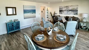 A dining area with a round table, light blue chairs, and a blue cabinet. - 10 Steps to the Sand…Capitola Beach Front at the mouth of the Wharf-Pet Friendly (Capitola)
