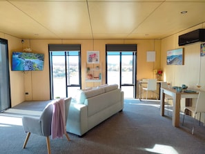 Relax in a spacious living area with a sofa set, flat-screen TV, and a dining table.