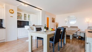A modern kitchen with white cabinets and a dining area with a table and chairs.