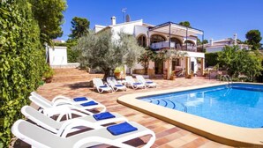 Uma área à beira da piscina com espreguiçadeiras e piscina.