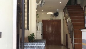 Un interior moderno con una escalera, un mostrador de recepción y una zona de estar.