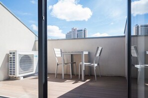 An outdoor balcony with a table and chairs, an air conditioning unit, and a view of a cityscape. - COMFY PORTO - Charming flat with terrace located in Porto centre (Porto)
