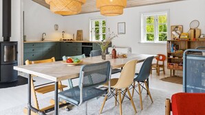 Une cuisine moderne dotée d’un grand îlot central, d’un plafond en bois et d’une cuisinière noire.